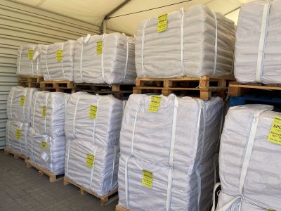 Close-up of stacked industrial big bags with yellow product labels containing SPORLIT slag coagulant agent