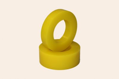 Two yellow highly wear-resistant polyurethane disc segments for conveyor belt rollers handling abrasive materials