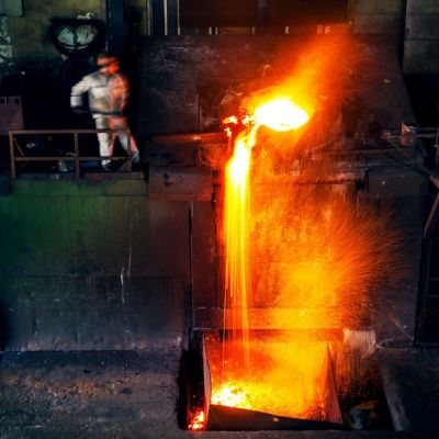 Deslagging process in a foundry showing the removal of bound slag from the molten metal surface
