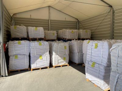 Warehouse storage showing stacked big bags of slag binder on wooden pallets ready for industrial shipping