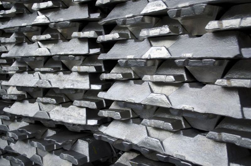 Industry view of stacked aluminum foundry ingots showing excellent surface quality achieved with specialized mold coatings