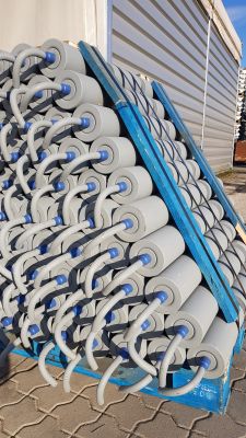 Stacked spring-loaded garland conveyor idlers ready for shipment or installation in bulk handling systems
