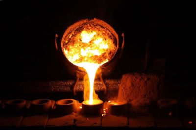 Molten metal being poured from a ladle into a mold after efficient slag treatment with SPORLIT