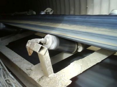 Spring-loaded garland idler station installed in a conveyor system, showing dynamic troughing and continuous belt contact