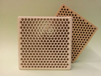 Two square-shaped extruded ceramic filters with precise round perforations for industrial slag retention