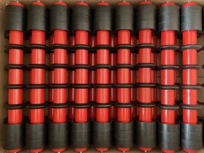 Transportbereit im Karton verpackte Tragrollen mit Gummiringen (Pufferringe) für die industrielle Fördertechnik