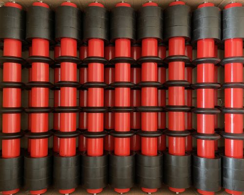 Transportbereit im Karton verpackte Tragrollen mit Gummiringen (Pufferringe) für die industrielle Fördertechnik