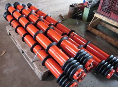 Conveyor idlers with rubber discs stacked on a pallet, secured and prepared for industrial logistics